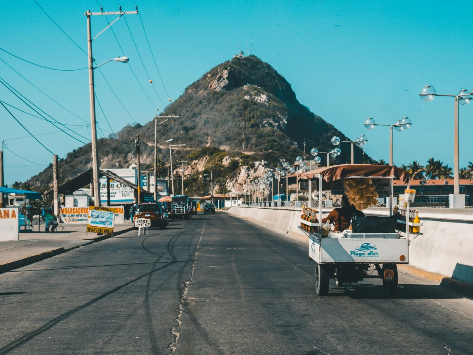 white auto rickshaw on riding on asphalt road towards green mountain